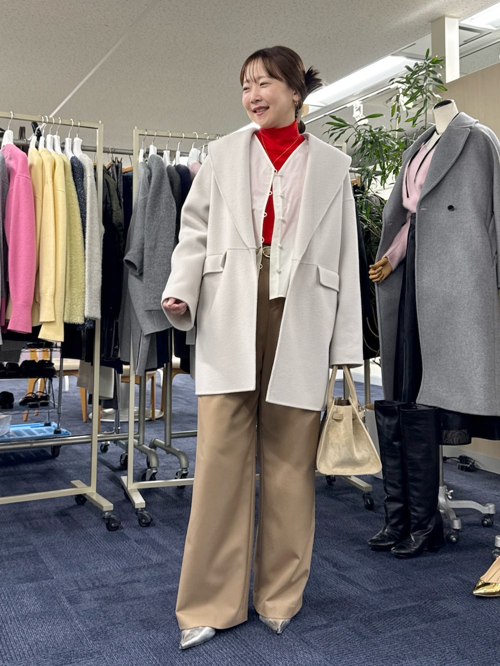 ベージュ系のその他アウター、ホワイト系のシャツ/ブラウス、レッド系のニット/セーターを着用したレディースの秋コーディネートの6枚目の写真