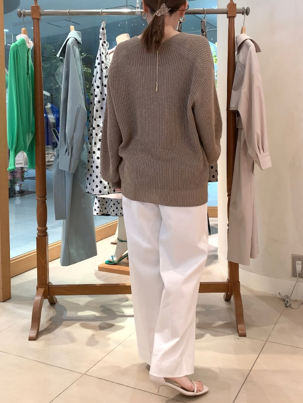 ベージュ系のニット/セーター、ホワイト系のキャミソール、ホワイト系のその他パンツを着用したレディースの春コーディネートの4枚目の写真