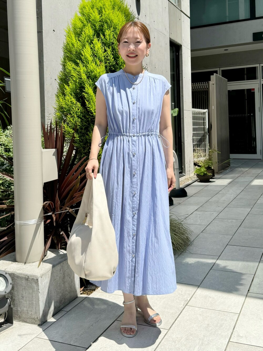 ブルー系のワンピース、ホワイト系のショルダーバッグ、シルバー系のサンダルを着用したレディースの夏コーディネートの3枚目の写真