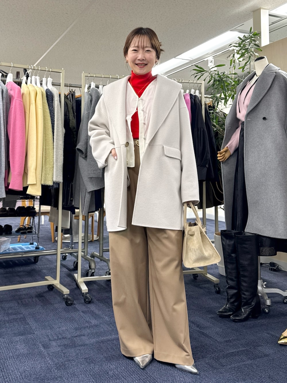 ベージュ系のその他アウター、ホワイト系のシャツ/ブラウス、レッド系のニット/セーターを着用したレディースの秋コーディネートの3枚目の写真