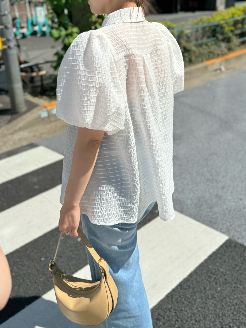 ホワイト系のシャツ/ブラウス、ベージュ系のショルダーバッグ、ブルー系のデニムパンツを着用したレディースの夏コーディネートの10枚目の写真