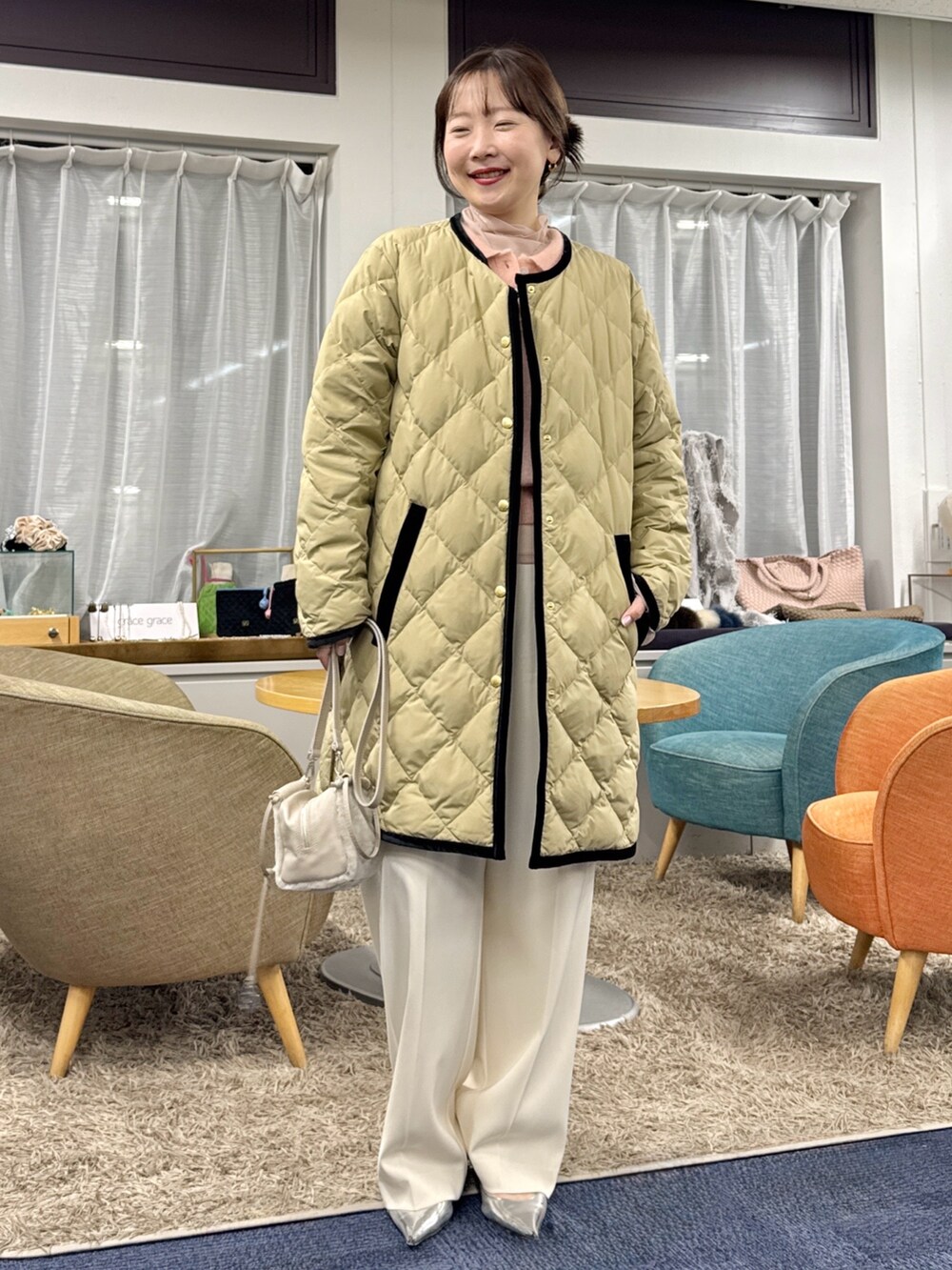 ベージュ系のショルダーバッグ、ベージュ系のダウンジャケット/コートを着用したレディースの秋コーディネートの6枚目の写真