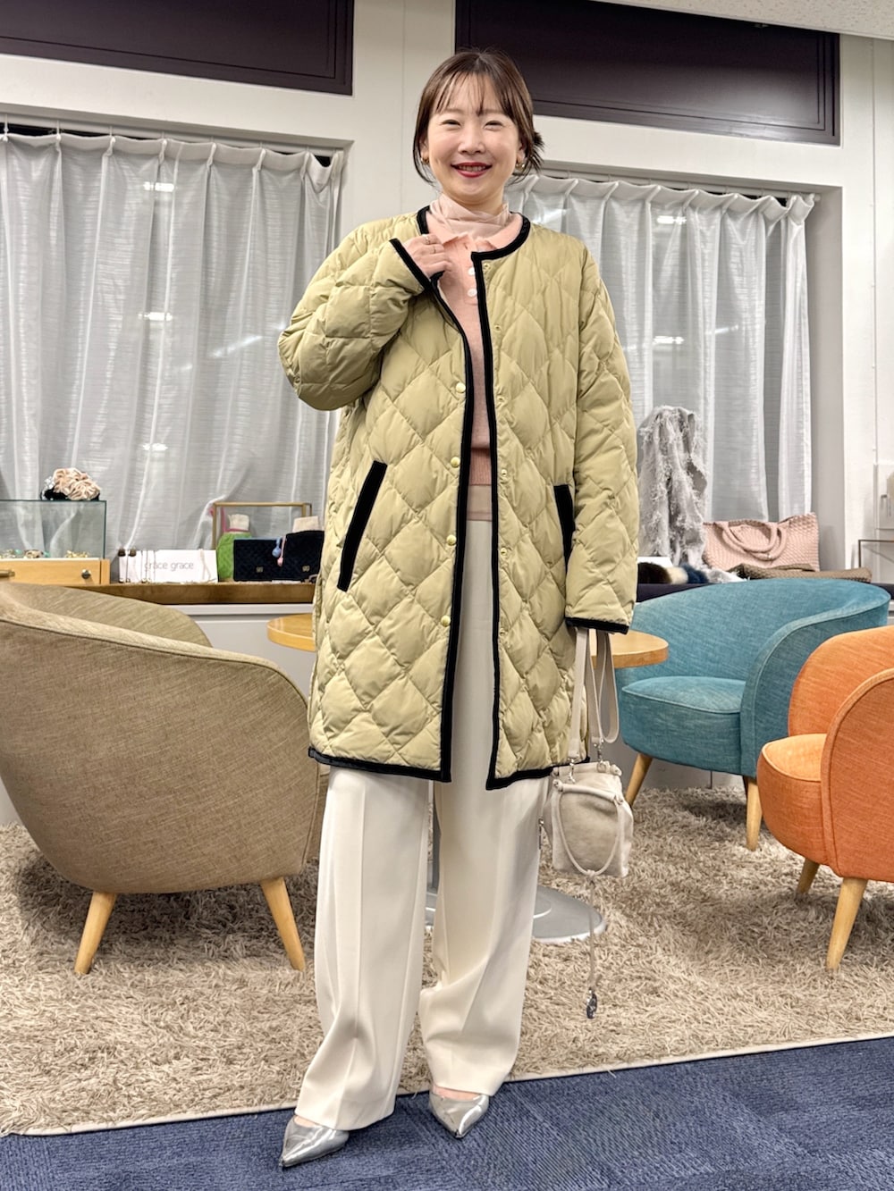 ベージュ系のショルダーバッグ、ベージュ系のダウンジャケット/コートを着用したレディースの秋コーディネートの5枚目の写真