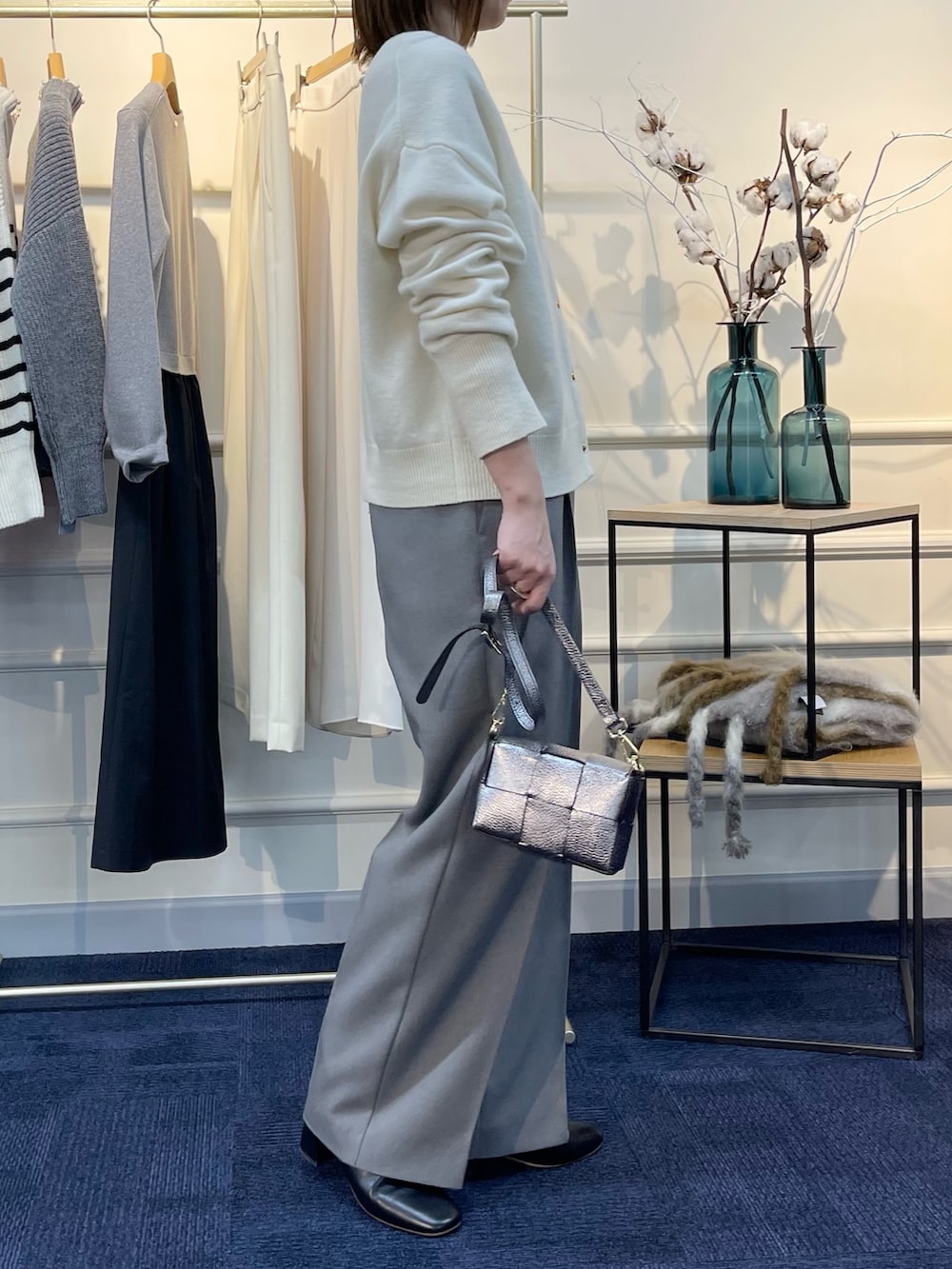 ホワイト系のカーディガン/ボレロ、ブラック系のブーツ、その他のショルダーバッグを着用したレディースの秋コーディネートの4枚目の写真