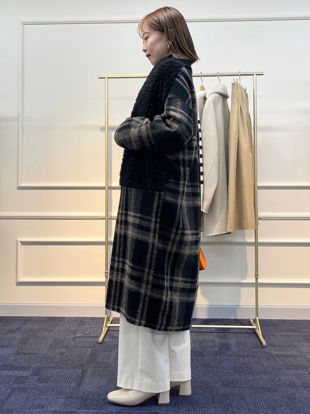 ブラウン系のニット/セーター、ブラック系のその他アウター、オレンジ系のショルダーバッグを着用したレディースの冬コーディネートの4枚目の写真