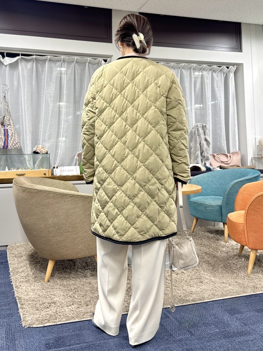 ベージュ系のショルダーバッグ、ベージュ系のダウンジャケット/コートを着用したレディースの秋コーディネートの9枚目の写真