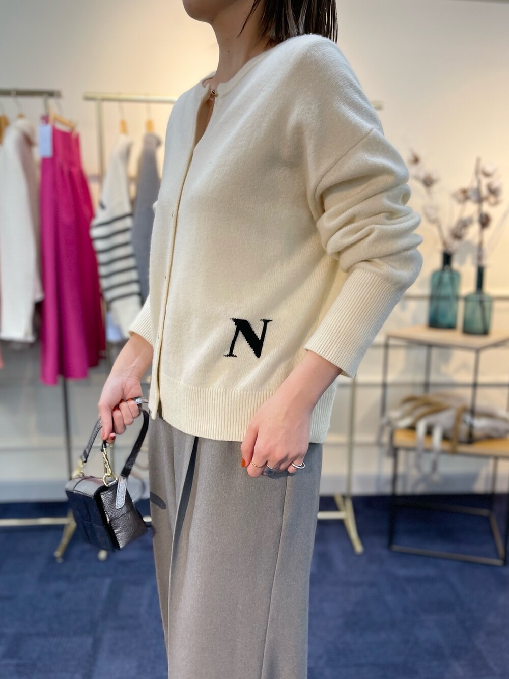 ホワイト系のカーディガン/ボレロ、ブラック系のブーツ、その他のショルダーバッグを着用したレディースの秋コーディネートの6枚目の写真