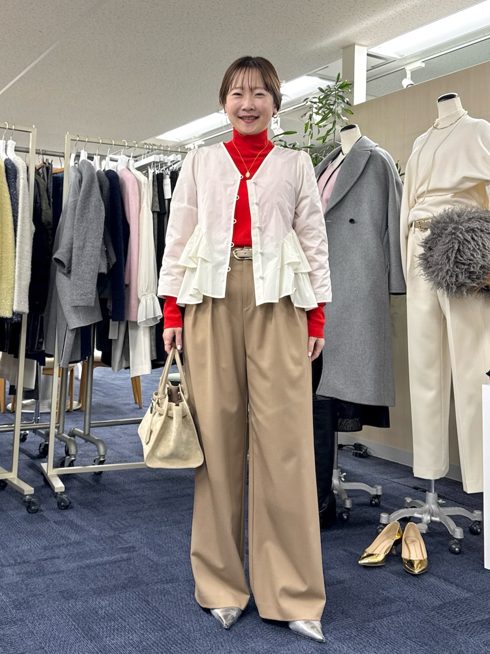 ベージュ系のその他アウター、ホワイト系のシャツ/ブラウス、レッド系のニット/セーターを着用したレディースの秋コーディネートの7枚目の写真