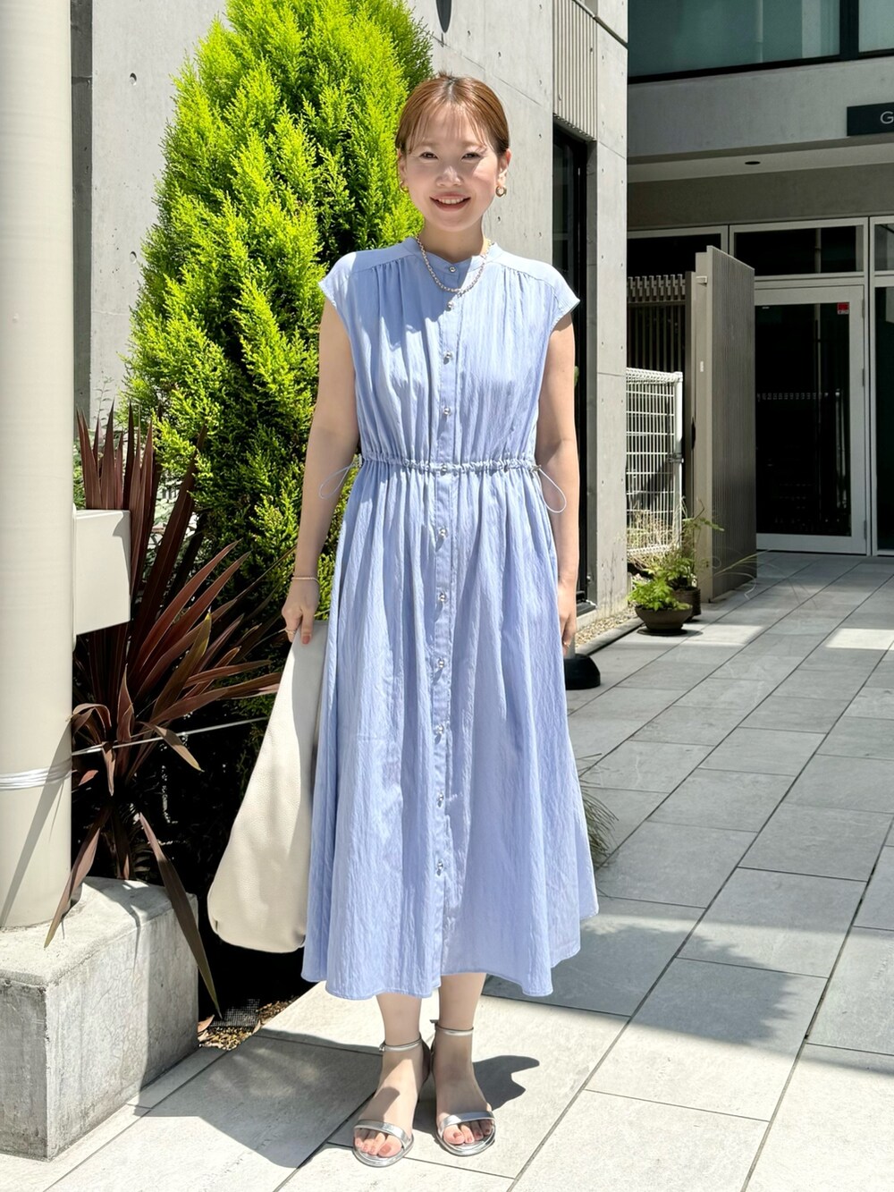 ブルー系のワンピース、ホワイト系のショルダーバッグ、シルバー系のサンダルを着用したレディースの夏コーディネートの2枚目の写真