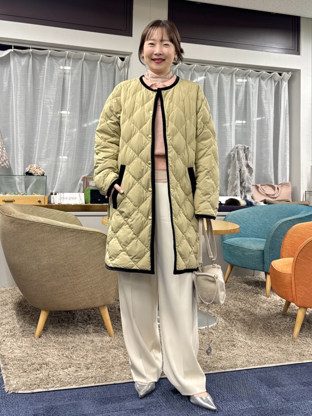 ベージュ系のショルダーバッグ、ベージュ系のダウンジャケット/コートを着用したレディースの秋コーディネートの3枚目の写真