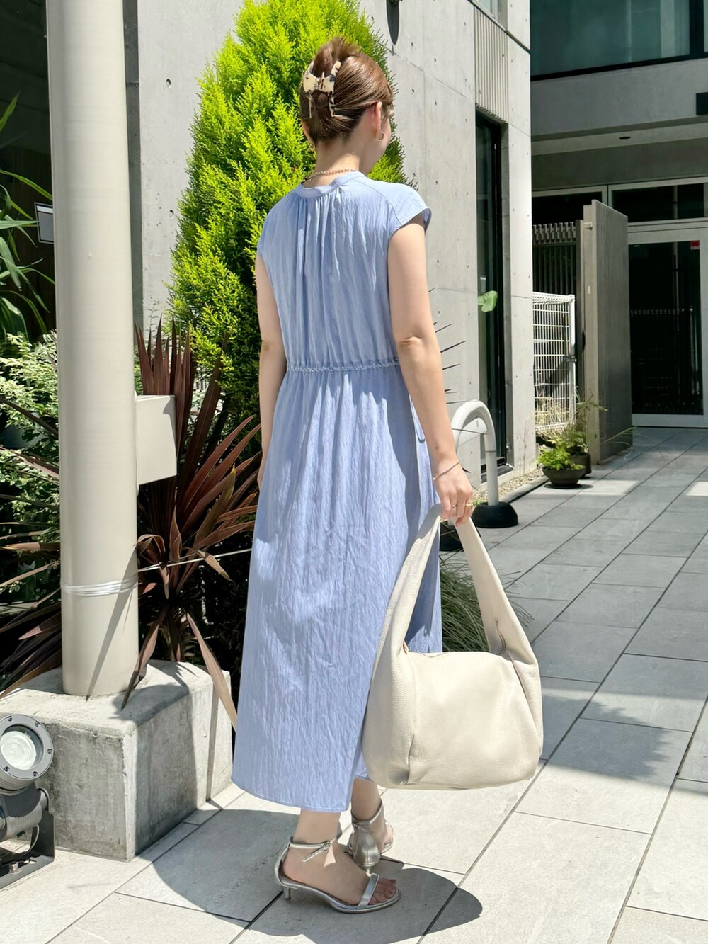 ブルー系のワンピース、ホワイト系のショルダーバッグ、シルバー系のサンダルを着用したレディースの夏コーディネートの7枚目の写真