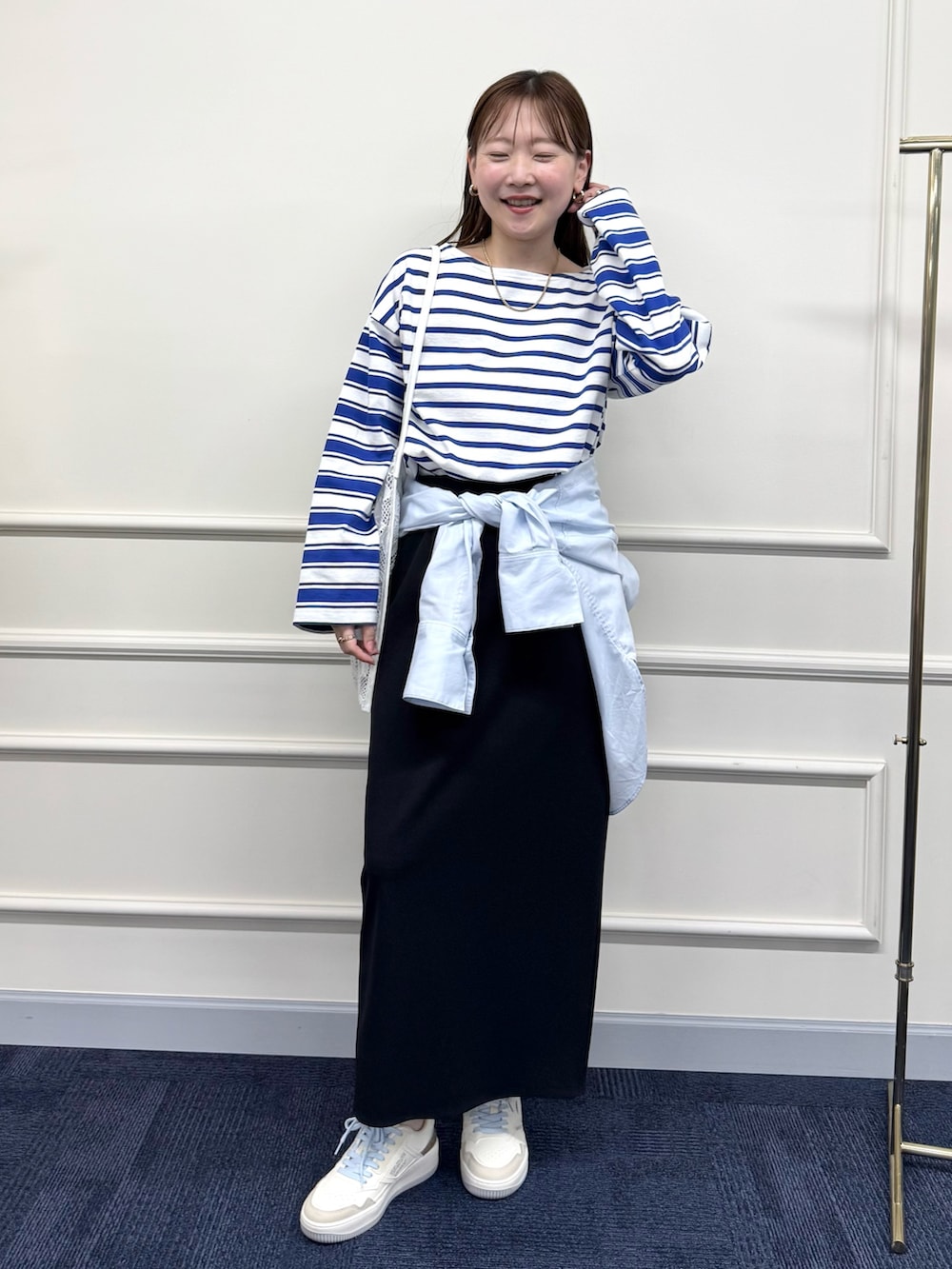 ブラック系のスカート、ブルー系のシャツ/ブラウス、ブルー系のTシャツ/カットソーを着用したレディースの春コーディネートの2枚目の写真