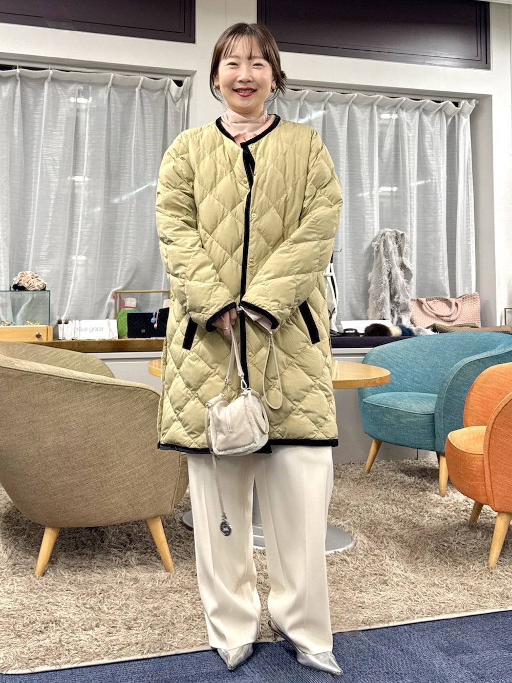 ベージュ系のショルダーバッグ、ベージュ系のダウンジャケット/コートを着用したレディースの秋コーディネートの2枚目の写真