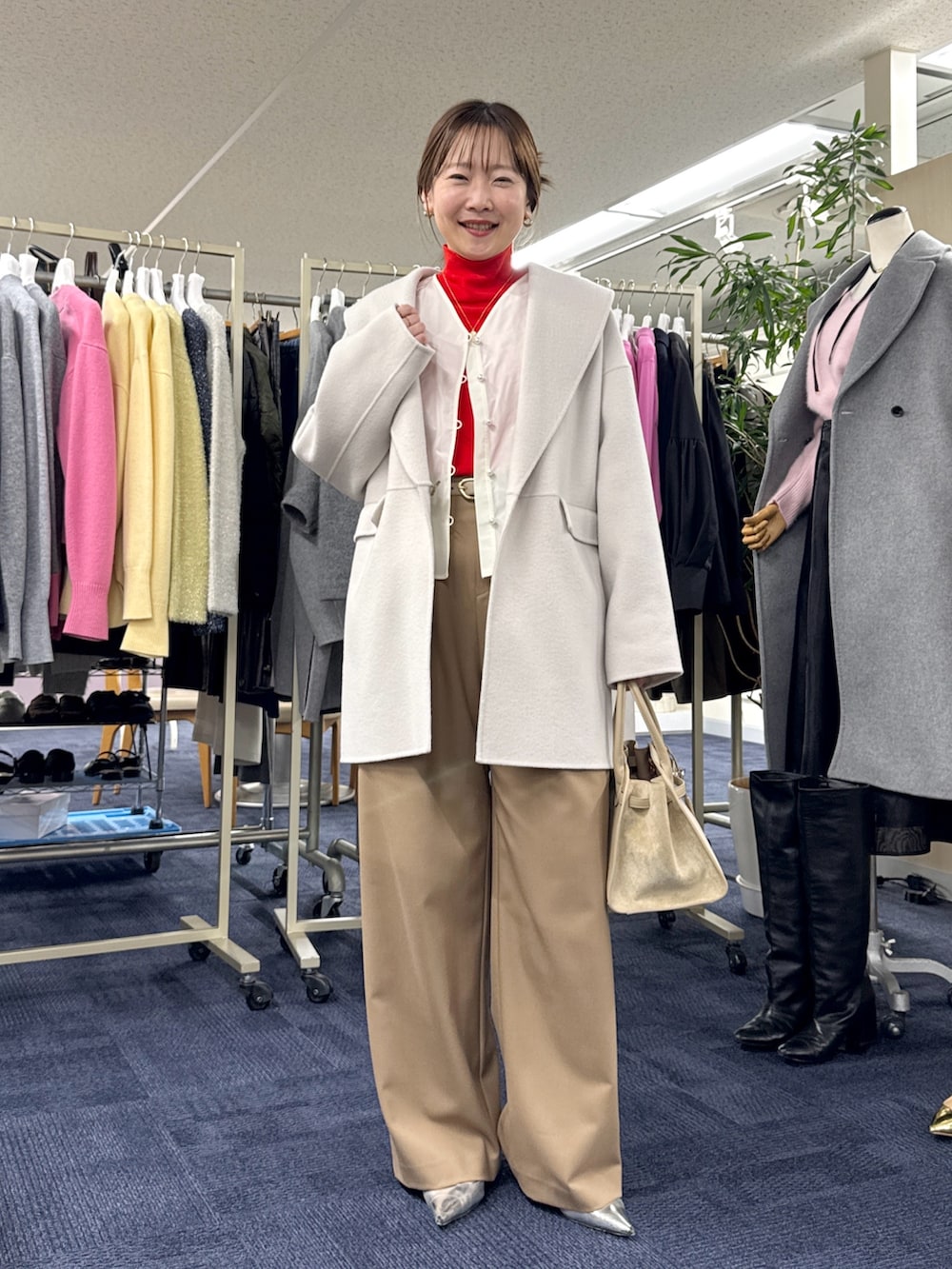 ベージュ系のその他アウター、ホワイト系のシャツ/ブラウス、レッド系のニット/セーターを着用したレディースの秋コーディネートの4枚目の写真