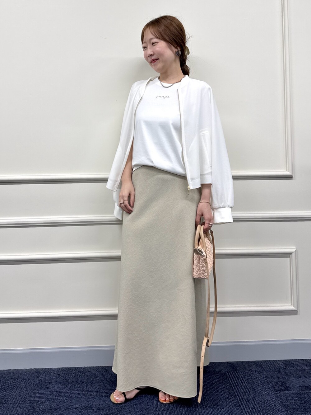 ベージュ系のスカート、ホワイト系のブルゾン、ホワイト系のTシャツ/カットソーを着用したレディースの夏コーディネートの6枚目の写真