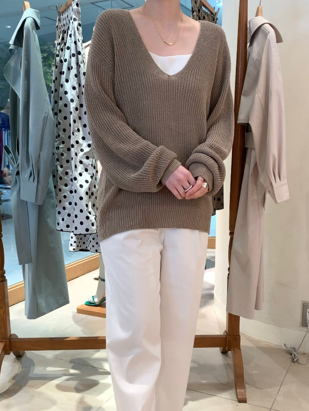 ベージュ系のニット/セーター、ホワイト系のキャミソール、ホワイト系のその他パンツを着用したレディースの春コーディネートの2枚目の写真