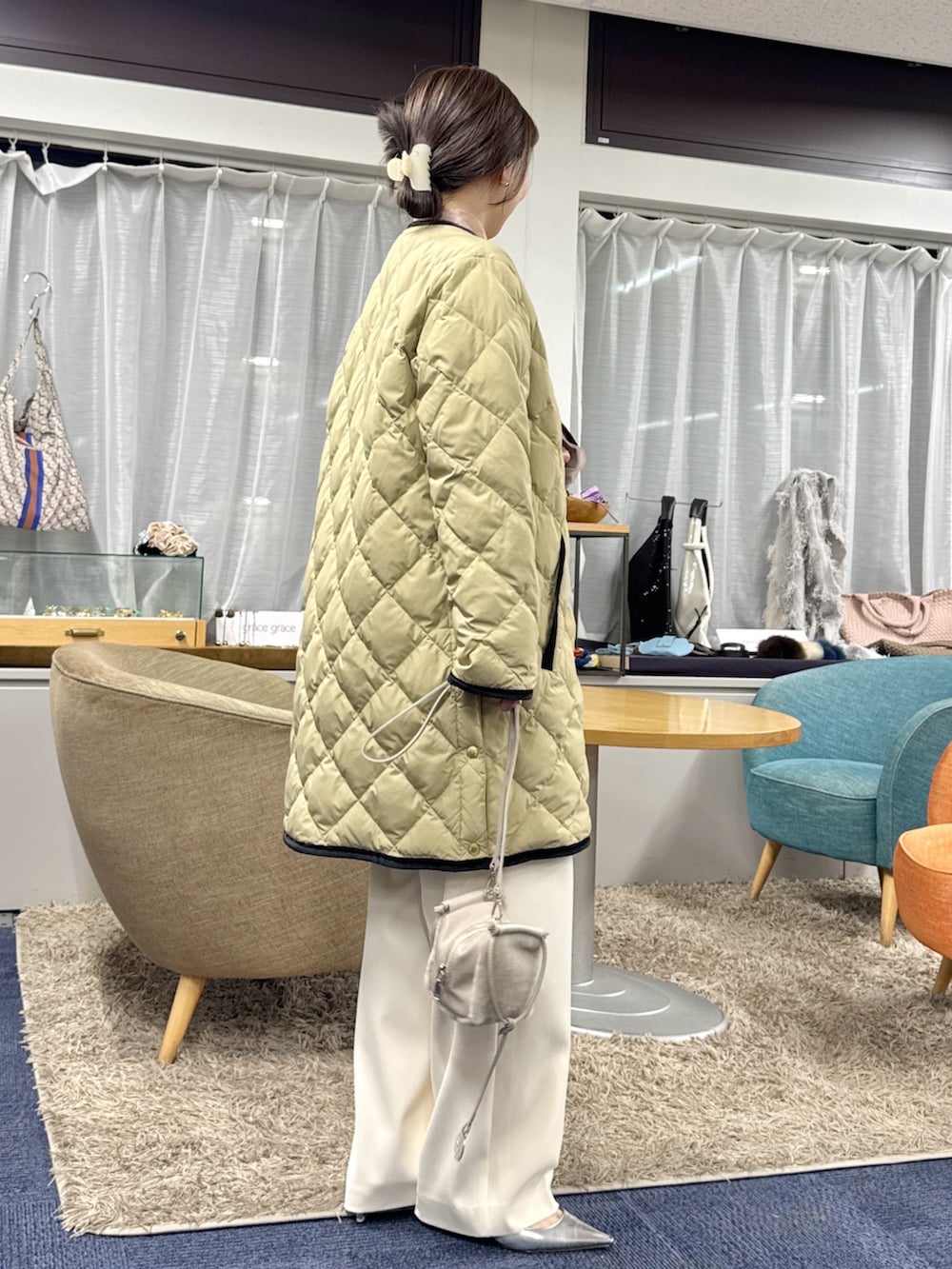 ベージュ系のショルダーバッグ、ベージュ系のダウンジャケット/コートを着用したレディースの秋コーディネートの8枚目の写真