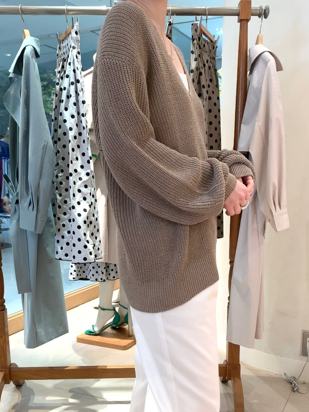 ベージュ系のニット/セーター、ホワイト系のキャミソール、ホワイト系のその他パンツを着用したレディースの春コーディネートの5枚目の写真