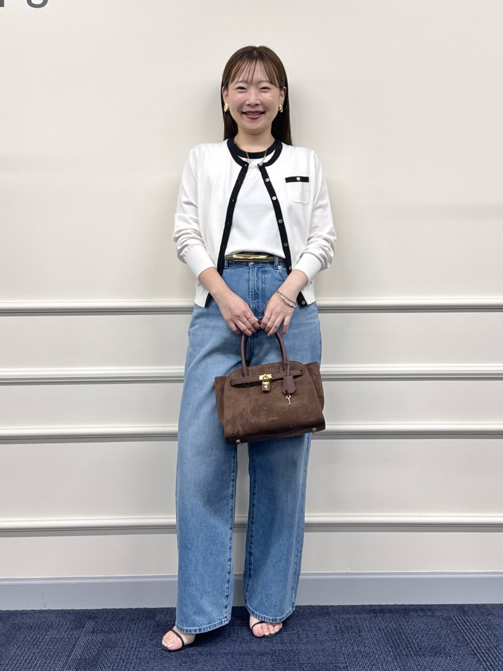 ブルー系のデニムパンツ、ブラウン系のトートバッグ、ホワイト系のカーディガン/ボレロを着用したレディースの夏コーディネートの4枚目の写真