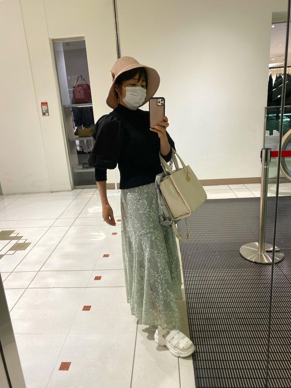 ブラック系のニット/セーター、グリーン系のスカート、ホワイト系のサンダルを着用したレディースの秋コーディネートの2枚目の写真