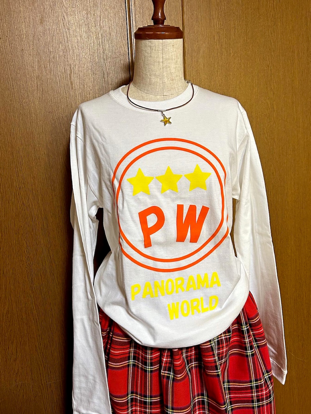 ブラック系のニット/セーター、ホワイト系のスカート、ピンク系のモカシン/デッキシューズを着用したレディースの秋コーディネートの2枚目の写真