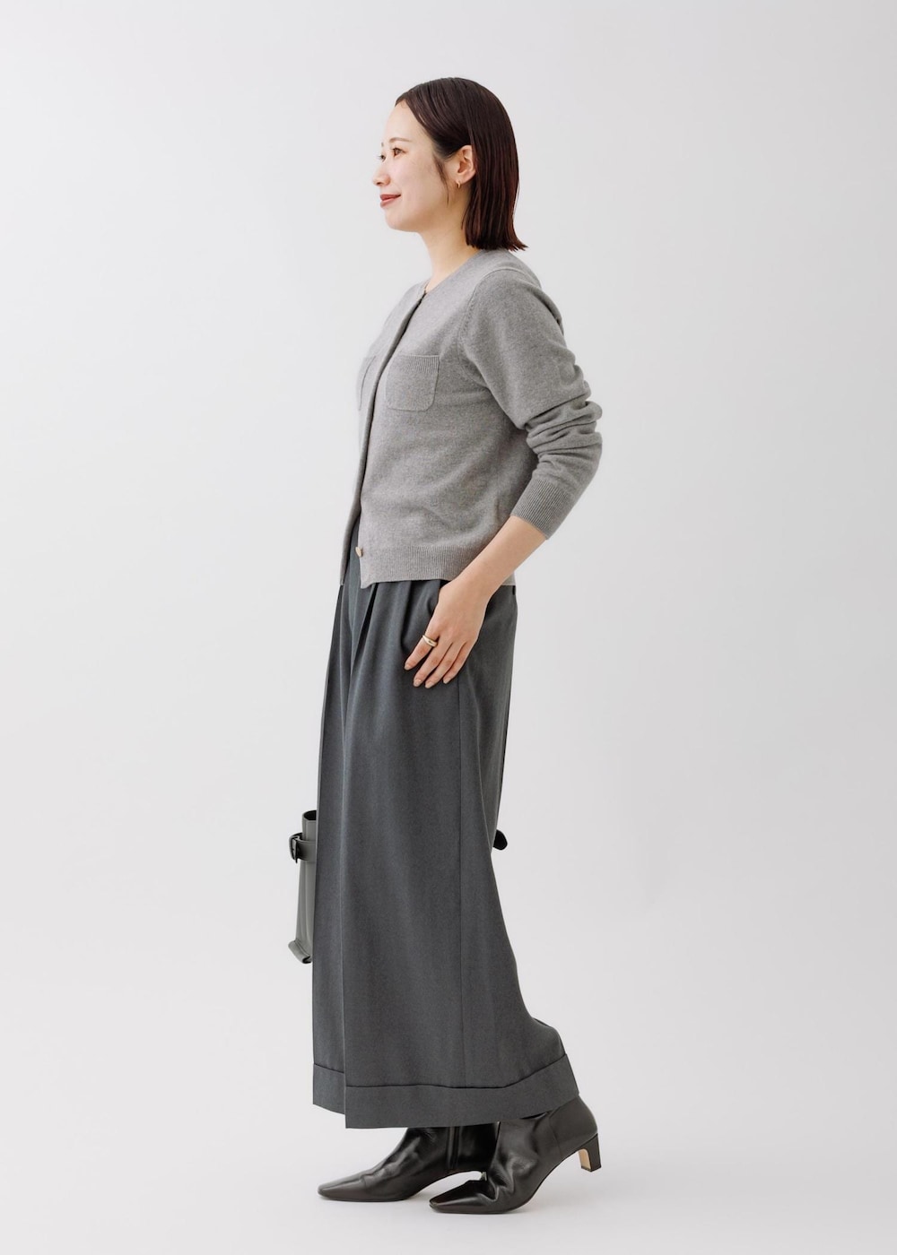 グレー系のニット/セーター、グレー系のその他パンツ、グレー系のハンドバッグを着用したレディースの秋コーディネートの3枚目の写真