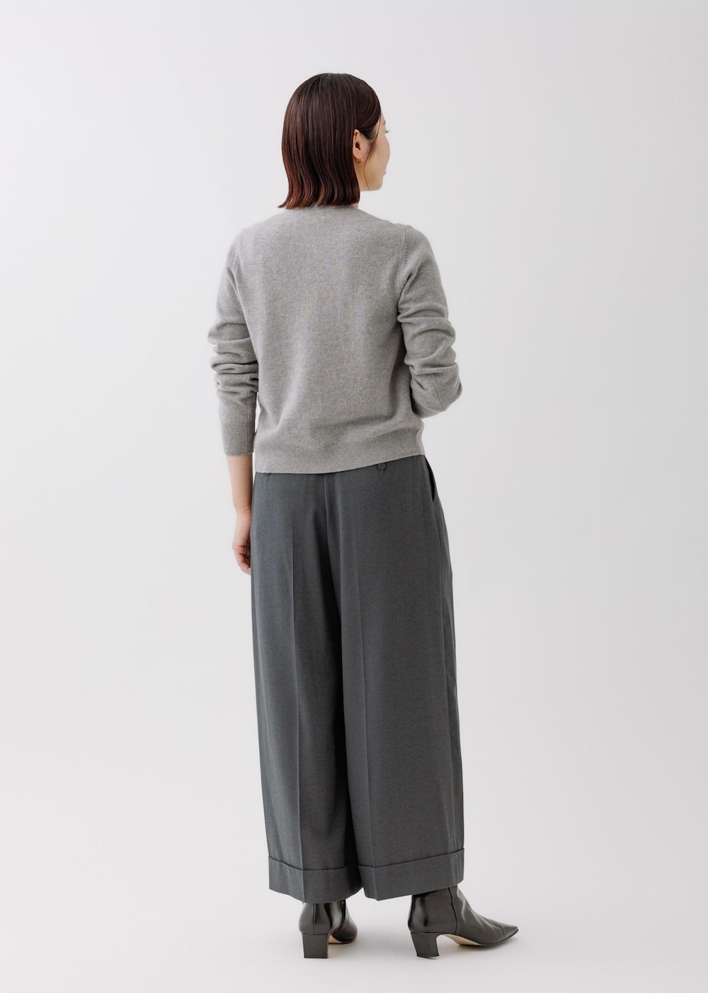 グレー系のニット/セーター、グレー系のその他パンツ、グレー系のハンドバッグを着用したレディースの秋コーディネートの2枚目の写真