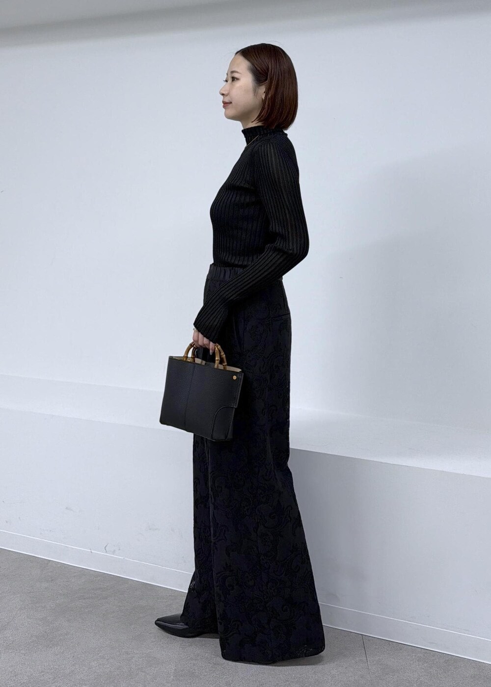 ブラック系のニット/セーター、ブラック系のその他パンツを着用したレディースの秋コーディネートの2枚目の写真