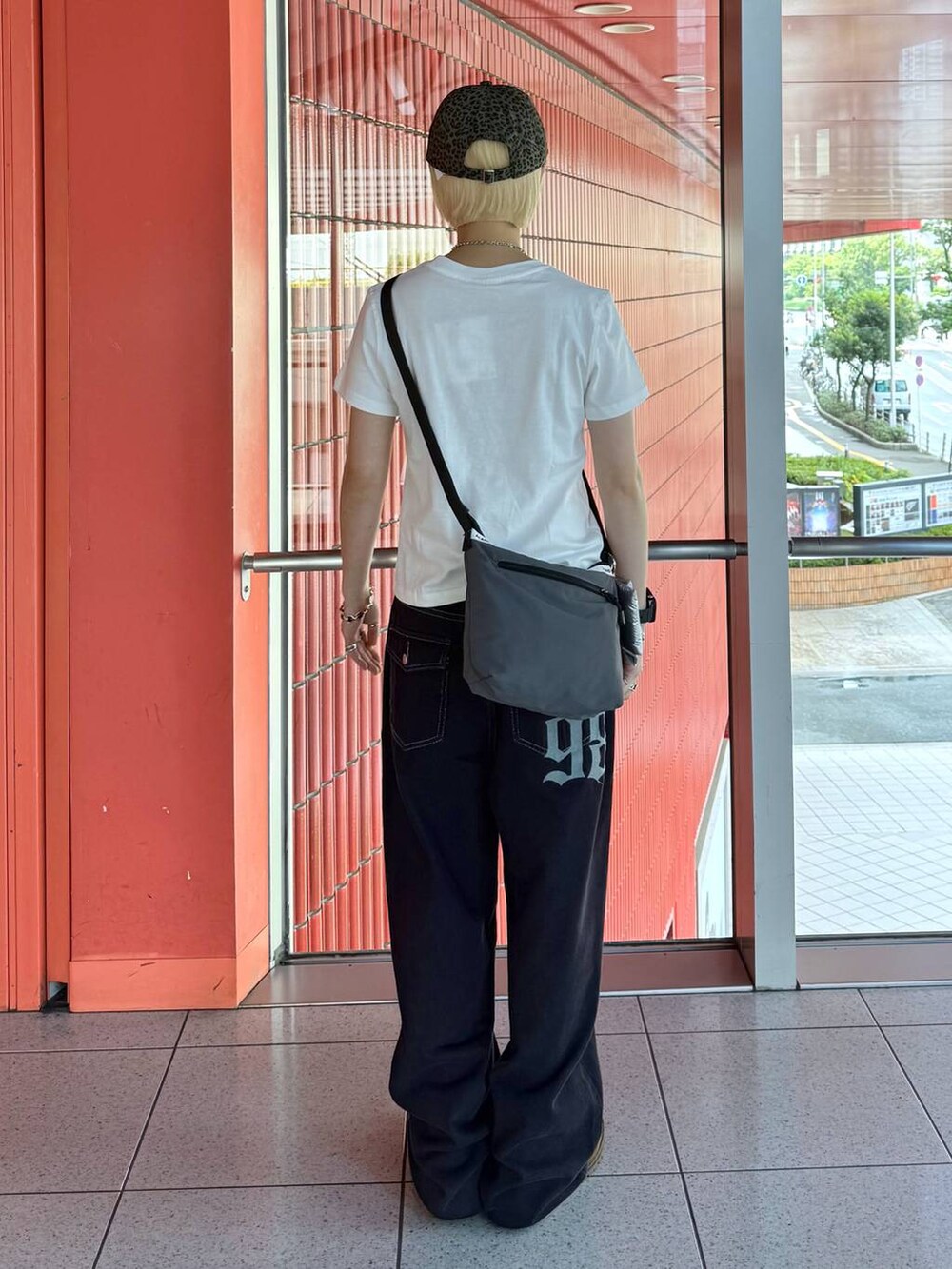 グレー系のショルダーバッグ、ブルー系のデニムパンツ、ホワイト系のTシャツ/カットソーを着用したレディースの夏コーディネートの4枚目の写真