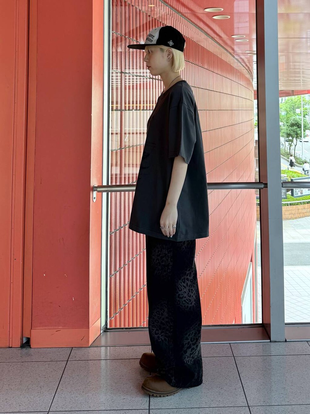 ブラック系のデニムパンツ、グレー系のTシャツ/カットソー、ブラック系のキャップを着用したレディースの春コーディネートの4枚目の写真