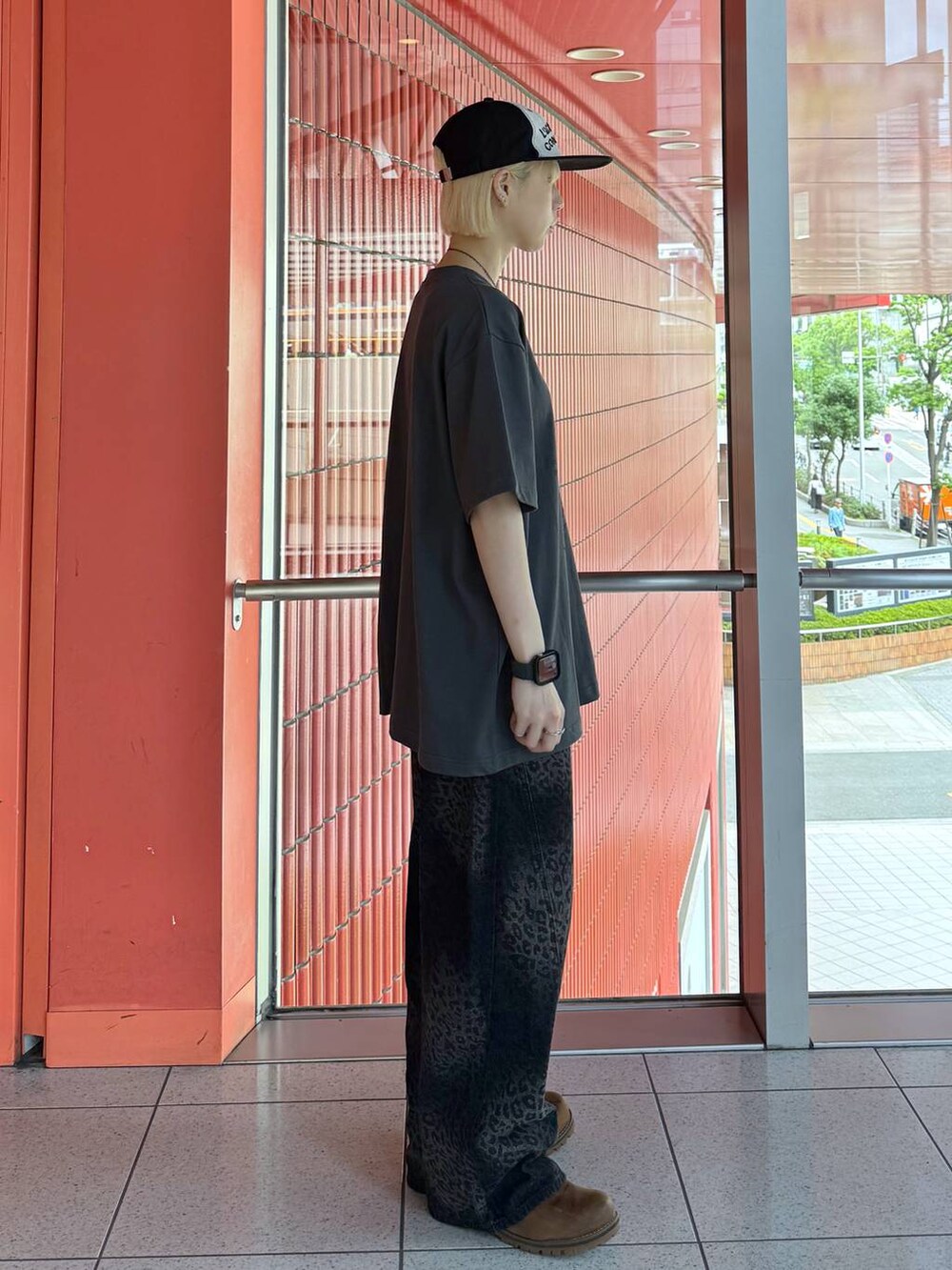 ブラック系のデニムパンツ、グレー系のTシャツ/カットソー、ブラック系のキャップを着用したレディースの春コーディネートの2枚目の写真