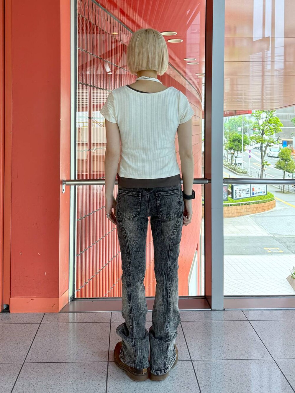 ブラック系のデニムパンツ、ホワイト系のTシャツ/カットソーを着用したレディースの春コーディネートの3枚目の写真