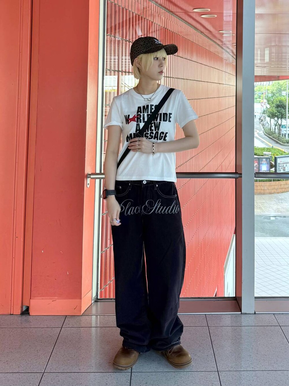 グレー系のショルダーバッグ、ブルー系のデニムパンツ、ホワイト系のTシャツ/カットソーを着用したレディースの夏コーディネートの2枚目の写真