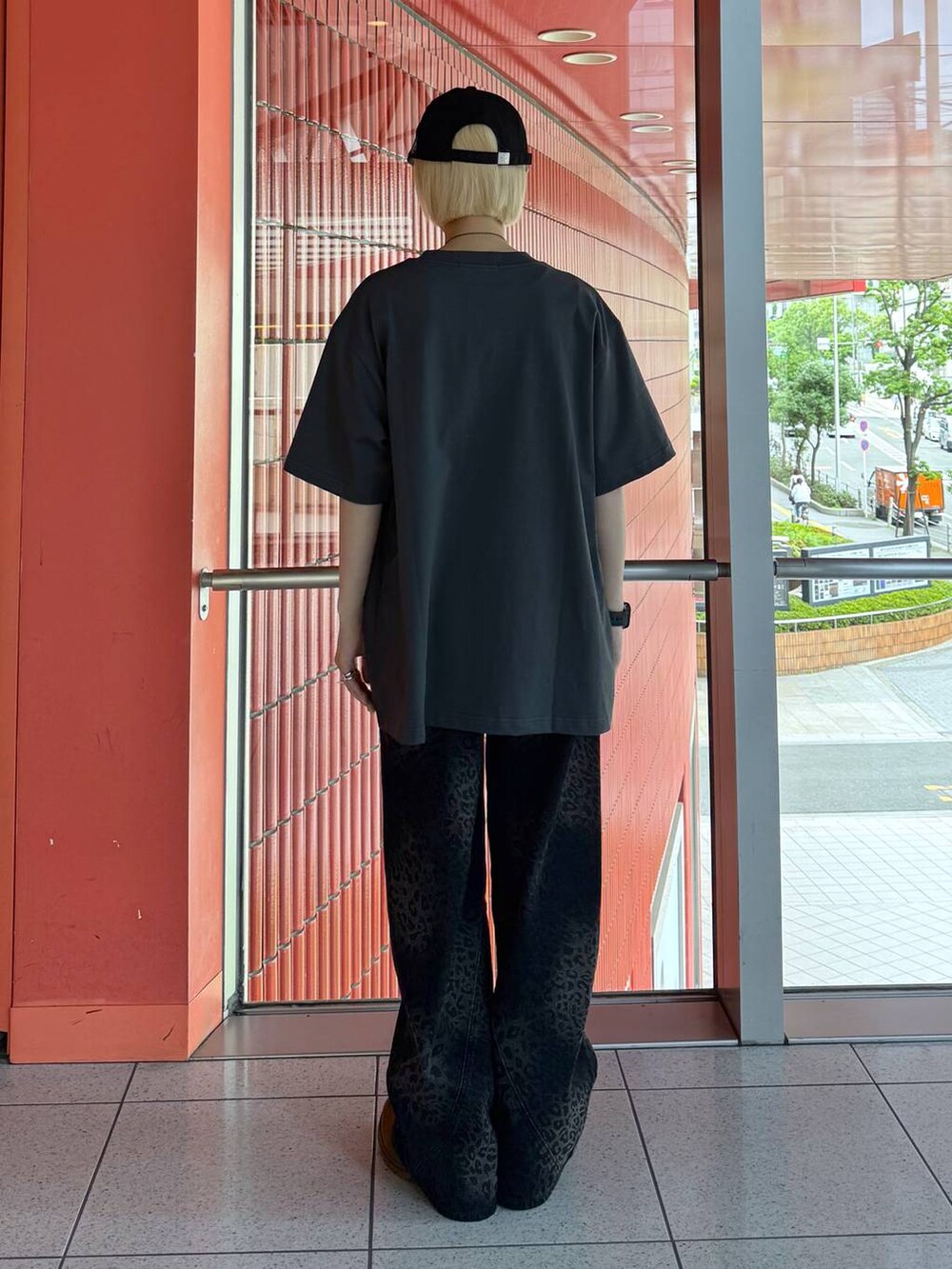 ブラック系のデニムパンツ、グレー系のTシャツ/カットソー、ブラック系のキャップを着用したレディースの春コーディネートの3枚目の写真