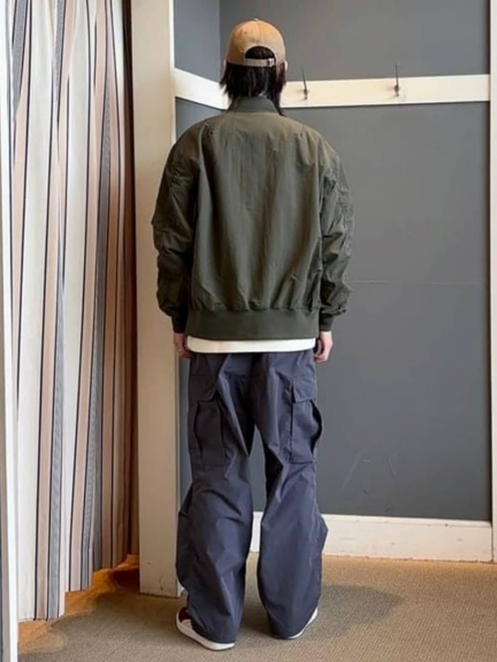 グリーン系のMA-1、ホワイト系のスウェット、グレー系のカーゴパンツを着用したメンズの冬コーディネートの2枚目の写真