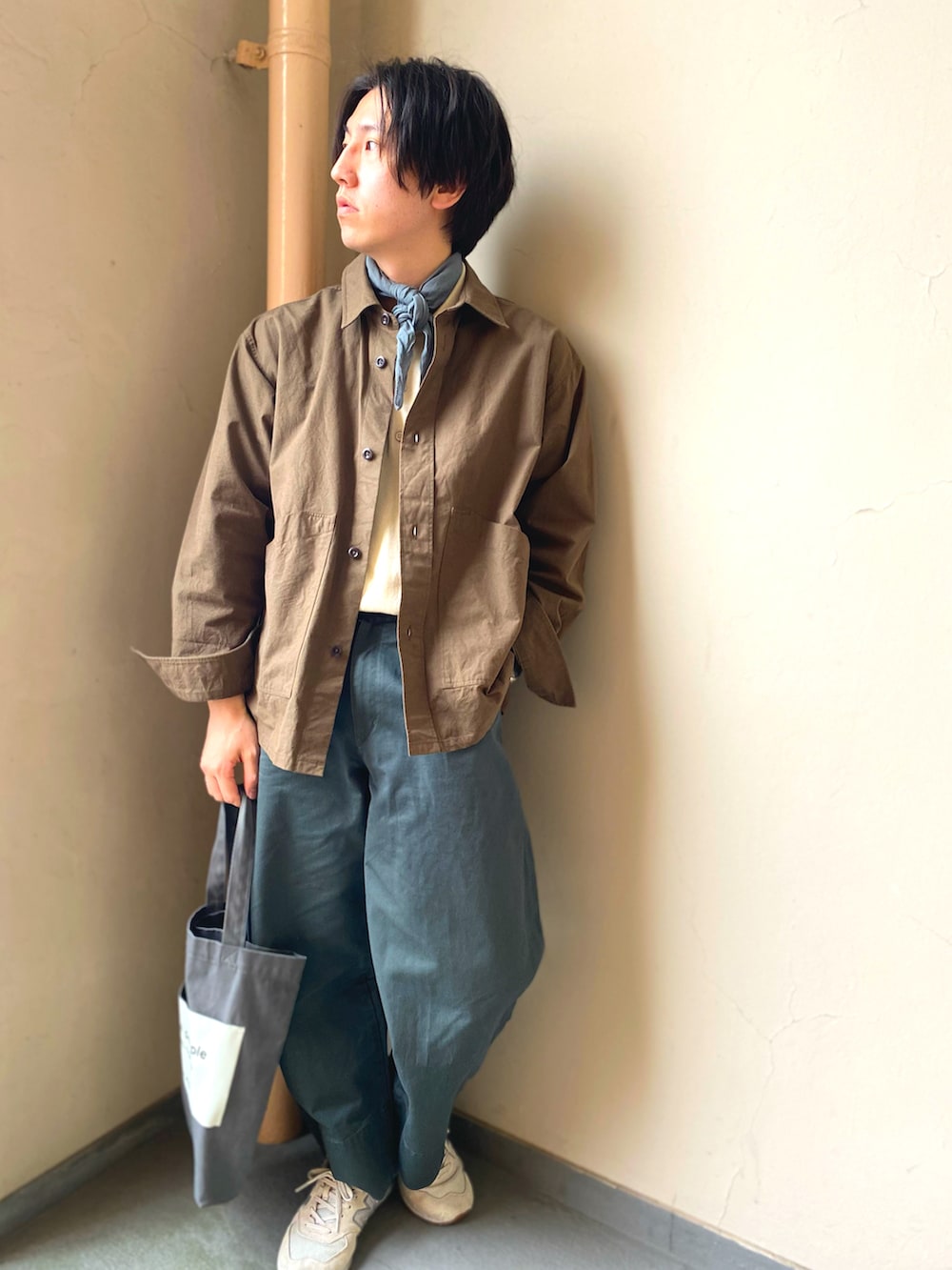 ホワイト系のニット/セーター、ブラウン系のシャツ/ブラウス、グリーン系のパンツを着用したメンズの春コーディネートの2枚目の写真