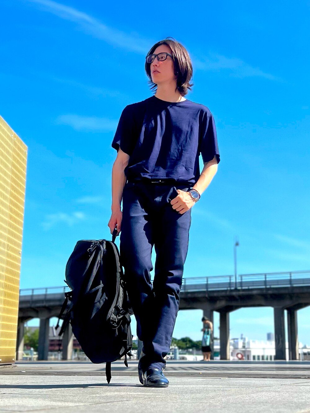 ブルー系のデニムパンツ、ブルー系のTシャツ/カットソー、ブラック系のバックパック/リュックを着用したメンズの夏コーディネートの2枚目の写真