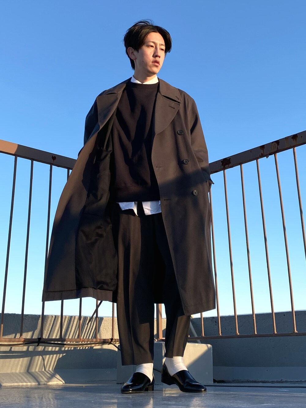 ホワイト系のシャツ/ブラウス、ブラック系のその他パンツ、グレー系のトレンチコートを着用したメンズの冬コーディネートの2枚目の写真