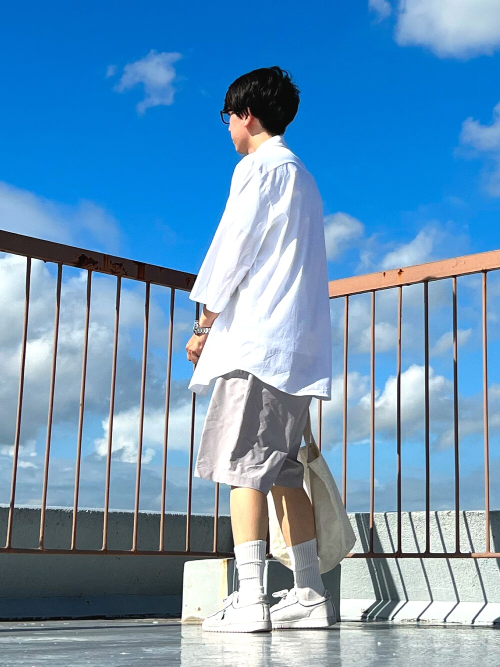 ホワイト系のシャツ/ブラウス、グレー系のその他パンツ、ホワイト系のトートバッグを着用したメンズの夏コーディネートの2枚目の写真