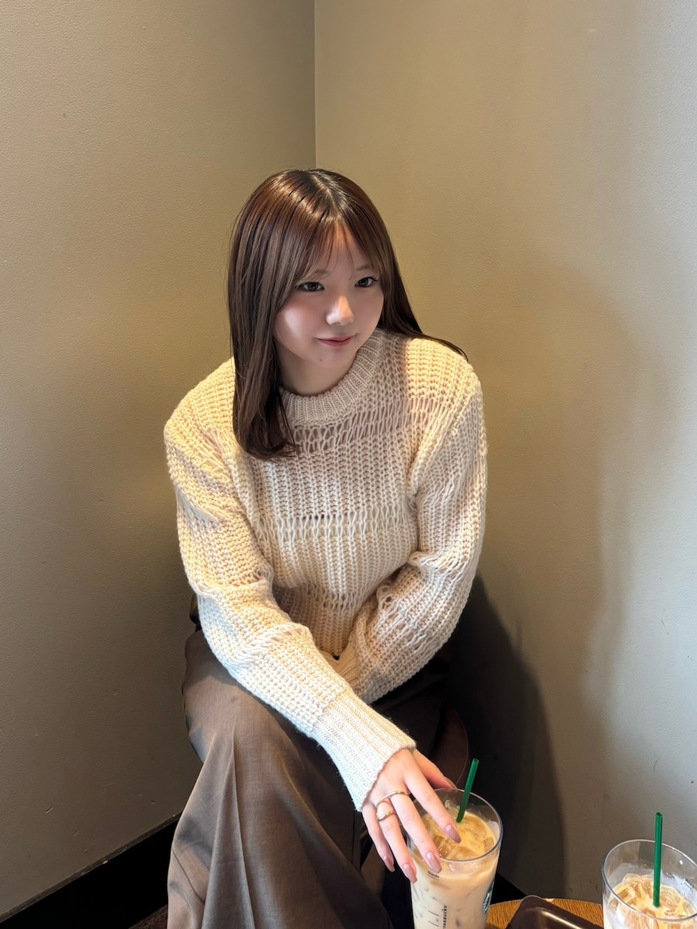 ホワイト系のニット/セーター、ホワイト系のキャミソール、ブラウン系のスラックスを着用したレディースの秋コーディネートの2枚目の写真