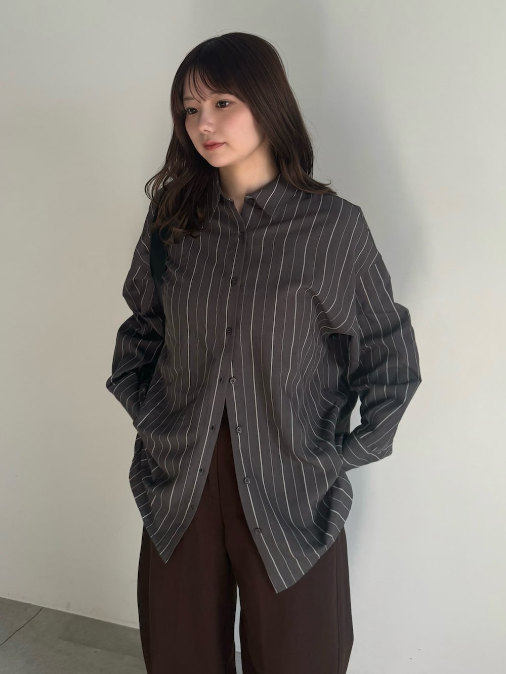 グレー系のシャツ/ブラウス、ブラック系のショルダーバッグ、ブラック系のスリッポンを着用したレディースの冬コーディネートの3枚目の写真