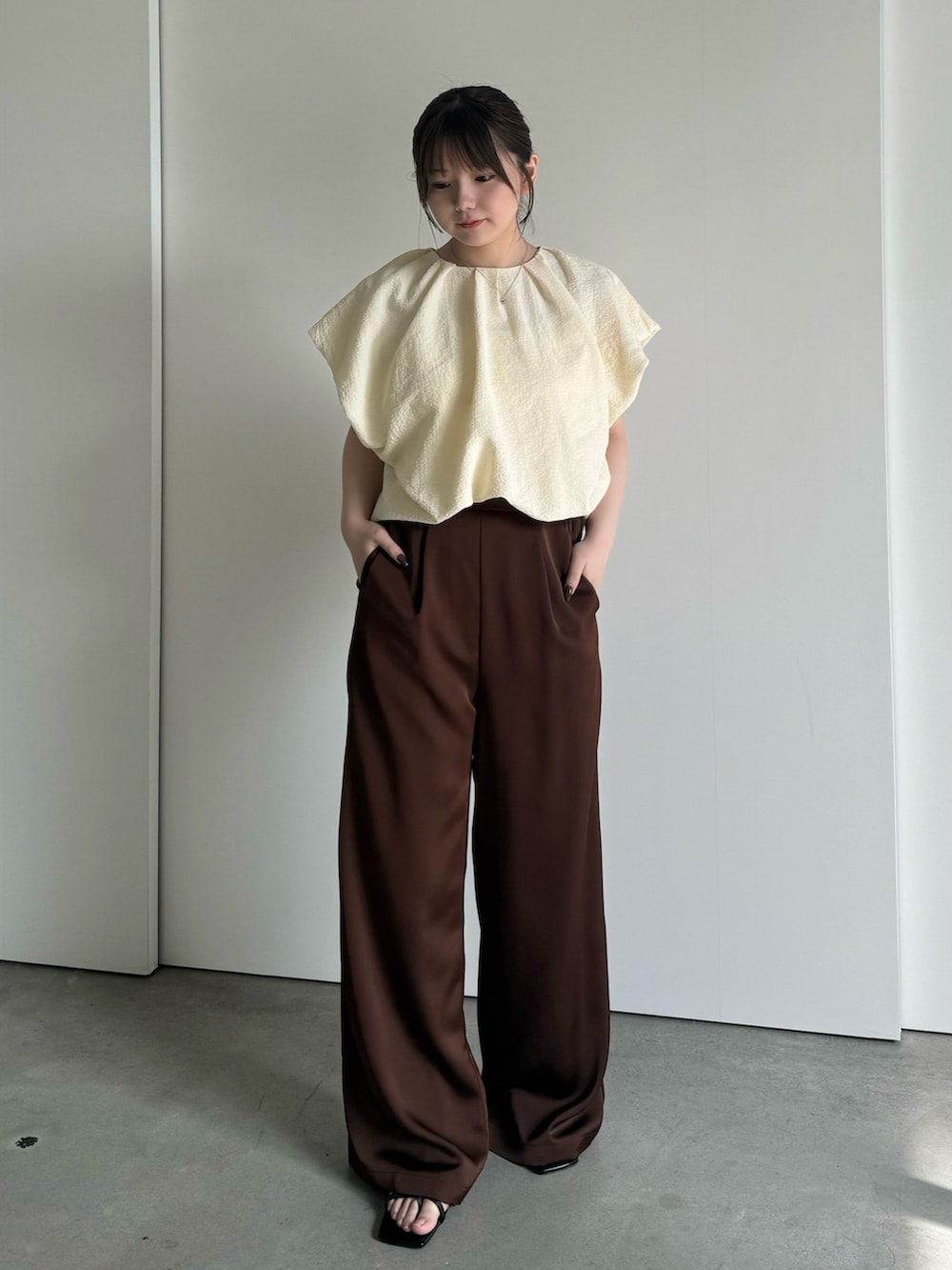 ブラウン系のその他パンツ、ブラック系のサンダルを着用したレディースの春コーディネートの3枚目の写真