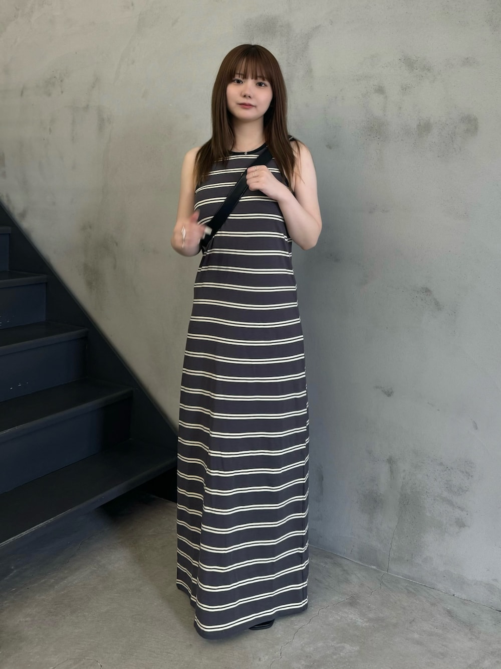 グレー系のワンピース、ブラック系のショルダーバッグ、ブラック系のサンダルを着用したレディースの夏コーディネートの4枚目の写真