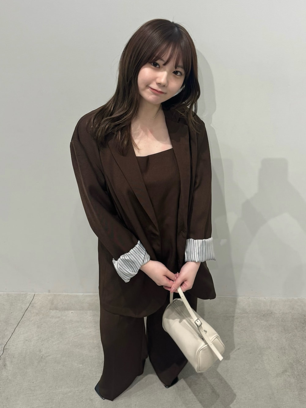 ブラウン系のテーラードジャケット、ブラウン系のキャミソール、ブラウン系のスラックスを着用したレディースの冬コーディネートの4枚目の写真