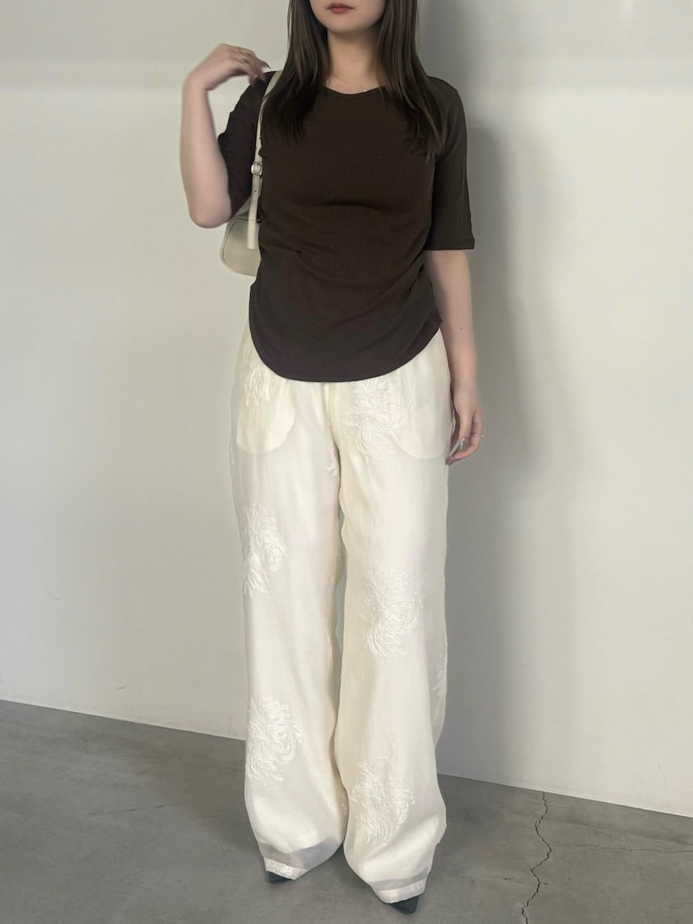 ブラウン系のTシャツ/カットソー、ホワイト系のその他パンツ、ホワイト系のハンドバッグを着用したレディースの夏コーディネートの2枚目の写真