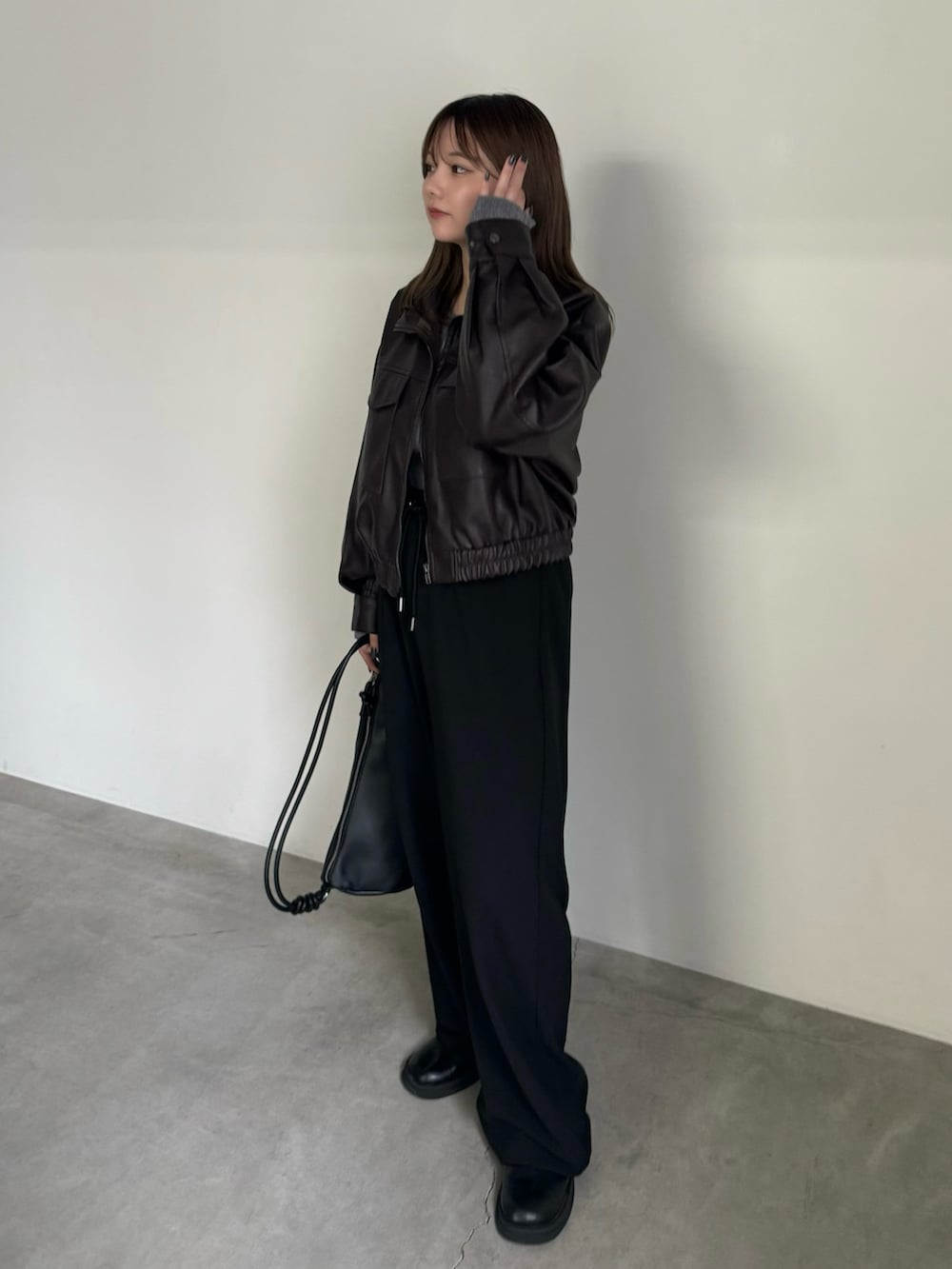 ブラウン系のブルゾン、グレー系のTシャツ/カットソー、ブラック系のその他パンツを着用したレディースの秋コーディネートの2枚目の写真