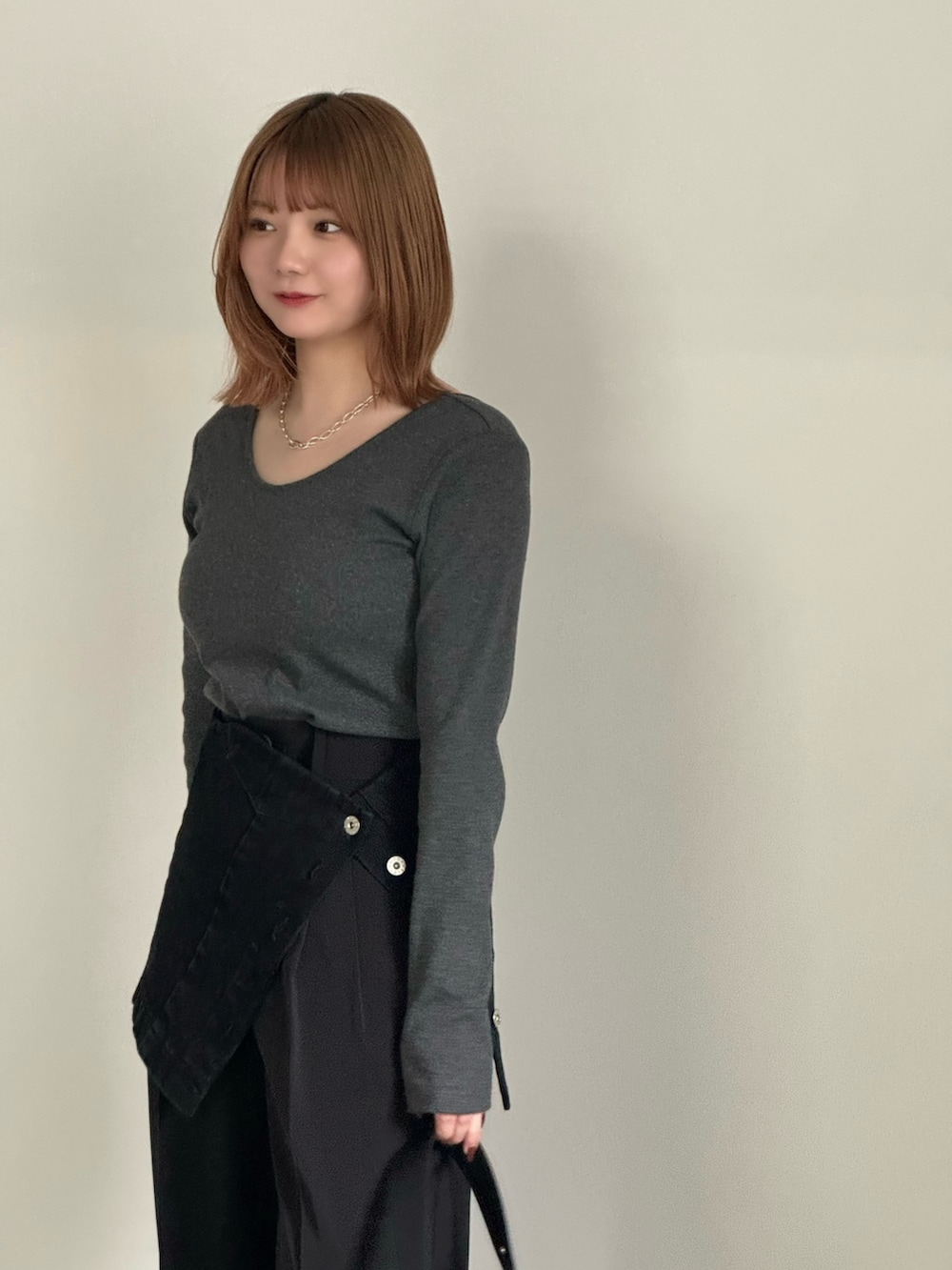 ブラック系のスラックス、ブラック系のチューブトップ、ブラック系のショルダーバッグを着用したレディースの春コーディネートの5枚目の写真