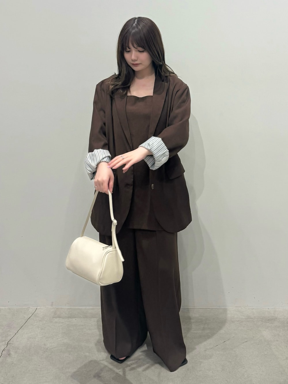 ブラウン系のテーラードジャケット、ブラウン系のキャミソール、ブラウン系のスラックスを着用したレディースの冬コーディネートの2枚目の写真