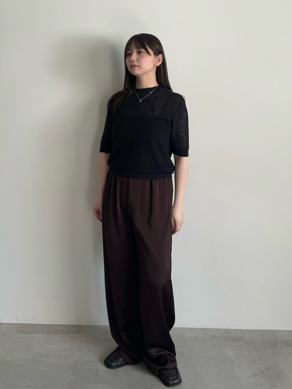 ブラック系のニット/セーター、ブラック系のキャミソール、ブラウン系のその他パンツを着用したレディースの春コーディネートの2枚目の写真