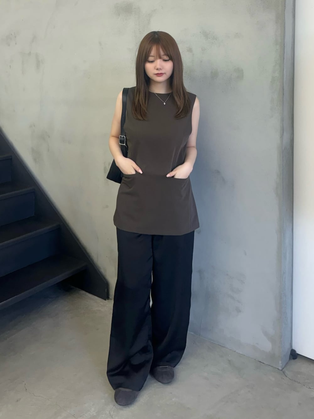 ブラウン系のベスト、ブラック系のその他パンツ、グレー系のスニーカーを着用したレディースの夏コーディネートの2枚目の写真
